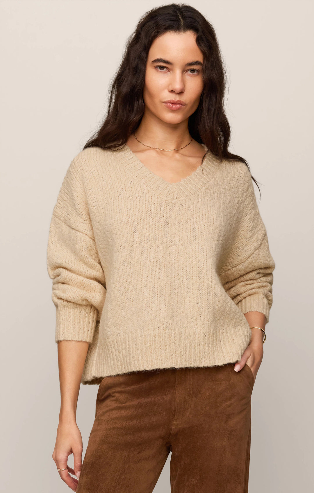Woman wearing Z Supply Bolton bouclé V-neck sweater in chalk white with denim