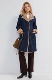 Woman wearing the Liverpool sherpa trimmed denim jacket in rinse wash, a long notch collar denim coat with teddy sherpa trim at the collar and cuffs.