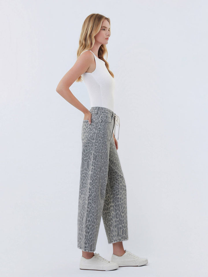 Side view of a woman wearing VERVET by Flying Monkey grey leopard high-rise drawstring barrel jeans with a white tank.