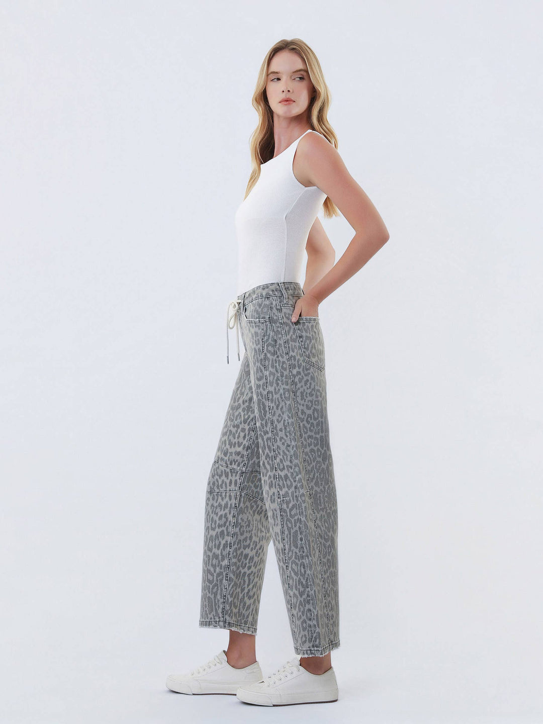 VERVET high-rise grey leopard barrel jeans with drawstring on a model in a white top and sneakers.